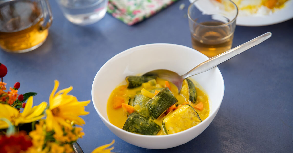 Eine Schüssel mit Essen auf einem gedeckten Tisch mit Blumen